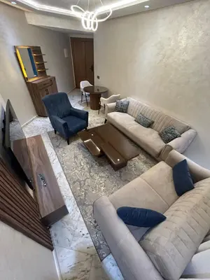 a living room with two couches and a tv at Chez BÉA in Rabat