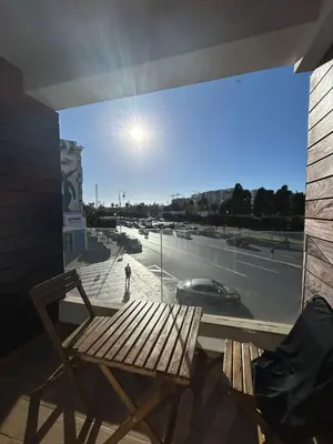 a chair on a balcony with a view of a street at Chez BÉA in Rabat