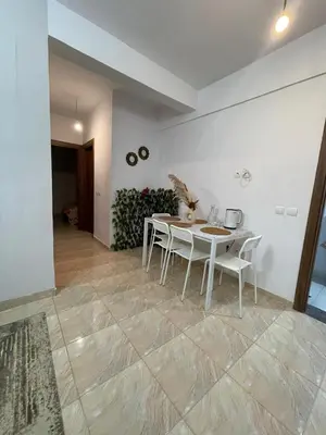 a white dining room with a table and chairs at High apartment in Oulad Hamida