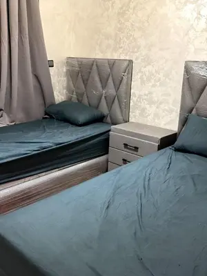 a bed and a chair in a room at Bel Appartement moderne et propre proche de l aéroport in Deroua