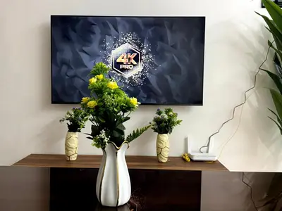 two vases with flowers on a table with a painting at Bel Appartement moderne et propre proche de l aéroport in Deroua
