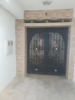 a black door in a fireplace with a stone wall at Sense house prime in Rabat