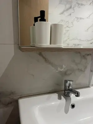 a bathroom with a sink and a shelf with toiletries at Studio moderne au centre ville avec wifi rapide in Maarif