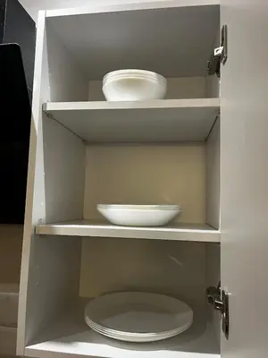 a white cabinet with two plates and a bowl at Studio moderne au centre ville avec wifi rapide in Maarif