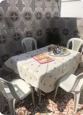 a table with white chairs and a white tablecloth on it at Hôte Nadia in Casablanca