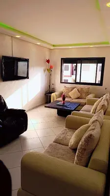 a living room with couches and a flat screen tv at Appartement Moderne avec Piscine in Bouznika