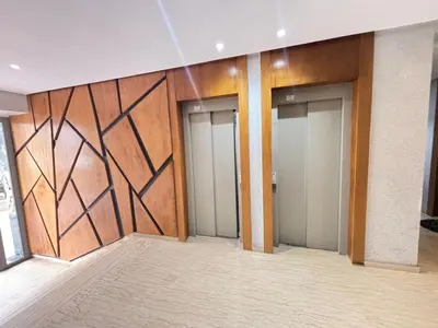 a row of elevators in a building with wooden walls at Cozy studio on the Casablanca Ain Diab corniche in Casablanca