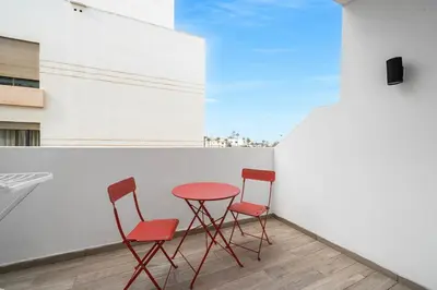 two red chairs and a red table on a balcony at Cozy studio on the Casablanca Ain Diab corniche in Casablanca