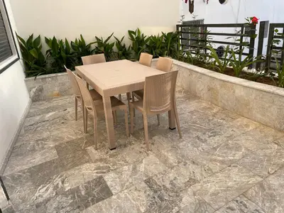 a wooden table and chairs on a patio at Appartement neuf luxe OLM Aviation à Rabat in Rabat