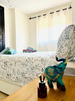 a toy elephant sitting on a table in front of a bed at Cozy & family apartment in Mohammedia in Mohammedia