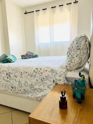 a bedroom with a bed and a wooden table at Cozy & family apartment in Mohammedia in Mohammedia