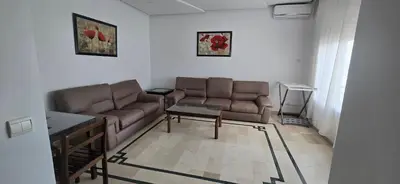 a living room with two brown couches and a table at Val danfa in Casablanca