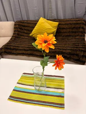 a vase with flowers on a table with a couch at Elégance & Confort in Rabat