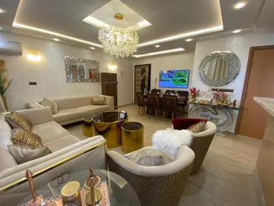 a living room with couches and a dining room at Apartement charmante amira in Oulad Kerroum