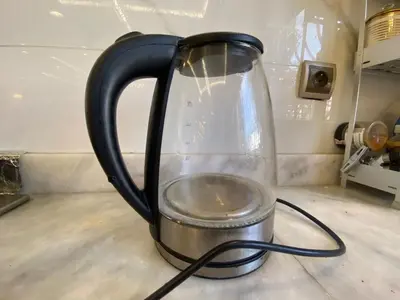 a glass jug with a black handle on a counter at Apartement charmante amira in Oulad Kerroum