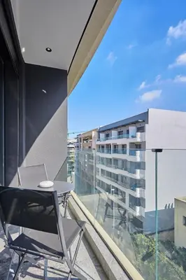 a balcony with a table and chairs and a building at Blue in Maarif