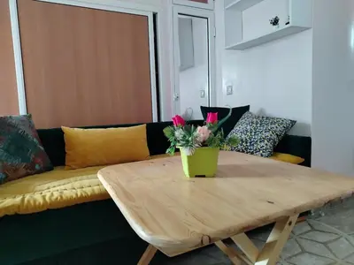 a coffee table with a vase of flowers on top of a couch at Appartement au centre rabat dyour jamaa in Rabat