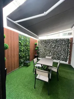 a room with a table and chairs and a green wall at Naturalia Appart & Hotel - Casa Center in Casablanca