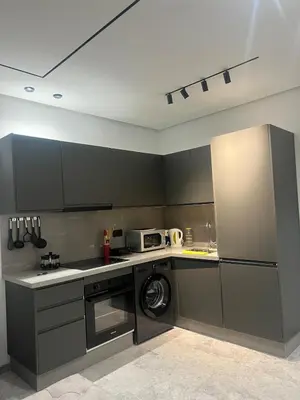 a kitchen with black cabinets and a washer at Naturalia Appart & Hotel - Casa Center in Casablanca