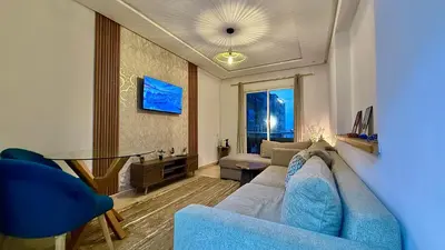 a living room with a blue couch and a table at Super appart vue sur mer in Rabat