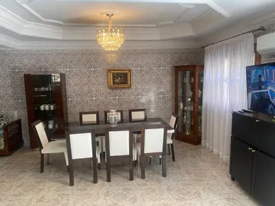 a dining room with a table and chairs and a chandelier at Tradition & Modernité in Rabat