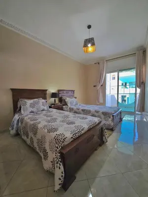 a bedroom with two beds and a large window at Appartement Rabat in Rabat