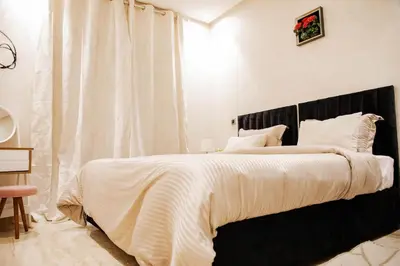 a bedroom with a large bed with a black headboard at Cozy Flat with Gym, fast WiFi and Great Location in Casablanca