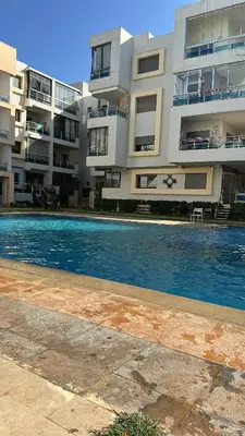 a swimming pool in front of a large building at Appartement de haut standing à EL MANSOURIA residence EBLA in Pont Blondin