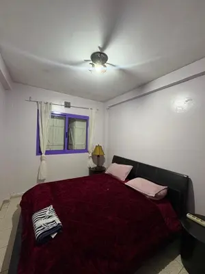 a bedroom with a bed with a red comforter at Palm Beach in Mansouria