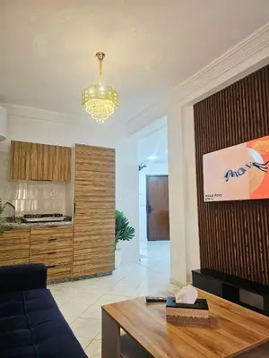a living room with a blue couch and a kitchen at CHIC Studio - Appartements proche du Arribat Center AGDAL in Rabat