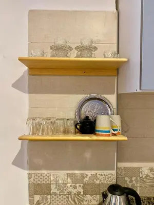 a shelf with a plate and cups on it at Social apartment in Rabat