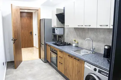 a kitchen with a sink and a refrigerator at Dar Bouazza Luxury apartment with pools garden sports courts parking near the sea in Dar Bouazza