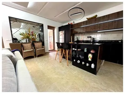a living room with a couch and a kitchen at Appartement Premium 3 Chambres Piscine et Accès Plage Mansouria in O Ben Slimane