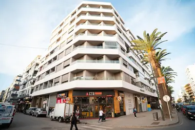 a tall white building with a palm tree in front of it at KeyLiving 501 3 pers Emplacement Top Wifi in Casablanca