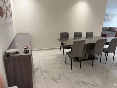 a dining room with a table and chairs at Superbe appartement 120 mc, Plage à pieds, 3 piscines & calme garanti - Sidi Rahal Plage in Sidi Rahal