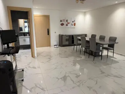a dining room with a table and chairs on a marble floor at Superbe appartement 120 mc, Plage à pieds, 3 piscines & calme garanti - Sidi Rahal Plage in Sidi Rahal