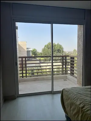 a bedroom with a large glass door to a balcony at Villa de luxe CGI avec piscine in Bouskoura