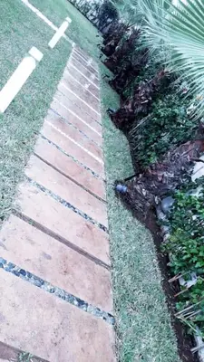 a brick walkway in the grass next to a yard at Villa de luxe CGI avec piscine in Bouskoura