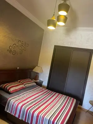 a bedroom with two beds with a striped blanket at Bel appartement in O Ben Slimane