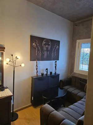 a living room with a couch and a table at Bel appartement in O Ben Slimane