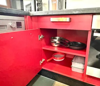 a red cabinet with some pots and pans on it at CityZen Suites, Luxury 3BR near Mohamed V Stadium in Maarif