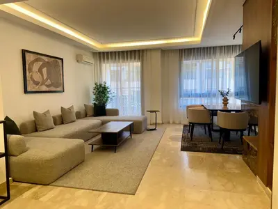 a living room with a couch and a table at CityZen Suites, Luxury 3BR near Mohamed V Stadium in Maarif