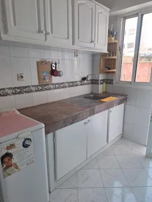 a kitchen with white cabinets and a counter top at Appartement cosy à Rabat Mer et commodités à pied in Rabat