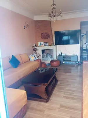 a living room with a couch and a table at Beach apartment with pool Skhirat beach in Skhirat