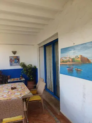 a dining room with a table and a painting on the wall at Beach apartment with pool Skhirat beach in Skhirat