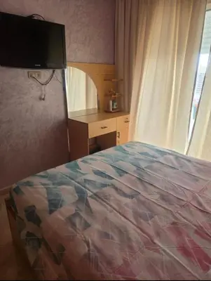 a bedroom with a bed and a desk and a television at Residence kettani in Bouznika