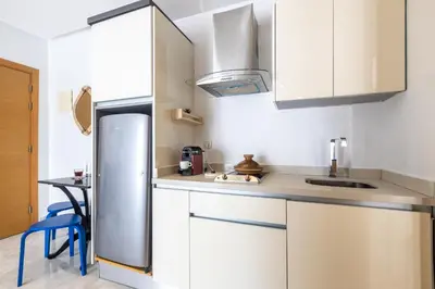 a kitchen with white cabinets and a stainless steel refrigerator at APGCI -Studio Élégant a 5 min du Stade Mohamed V in Casablanca