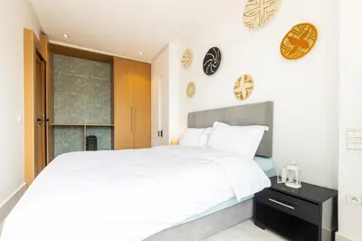 a bedroom with a white bed and a window at APGCI -Studio Élégant a 5 min du Stade Mohamed V in Casablanca