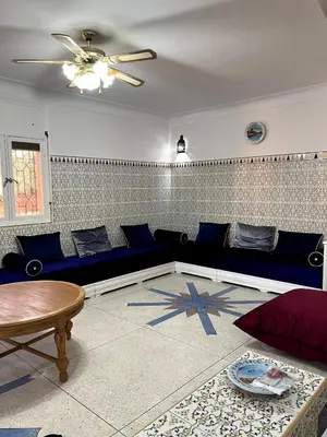 a living room with a blue couch and a table at Villa Haryouli in Azemmour