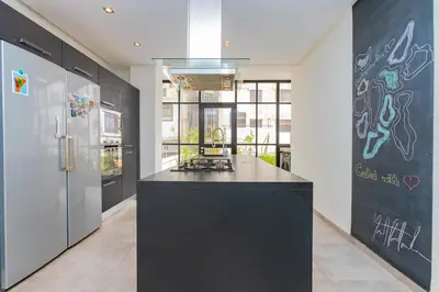 a kitchen with a black counter and a refrigerator at Luxury central Apartment - 3BR - Flipper - Parking in Casablanca